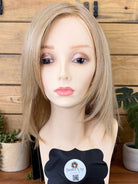 Blonde wig on a mannequin head with a wooden background