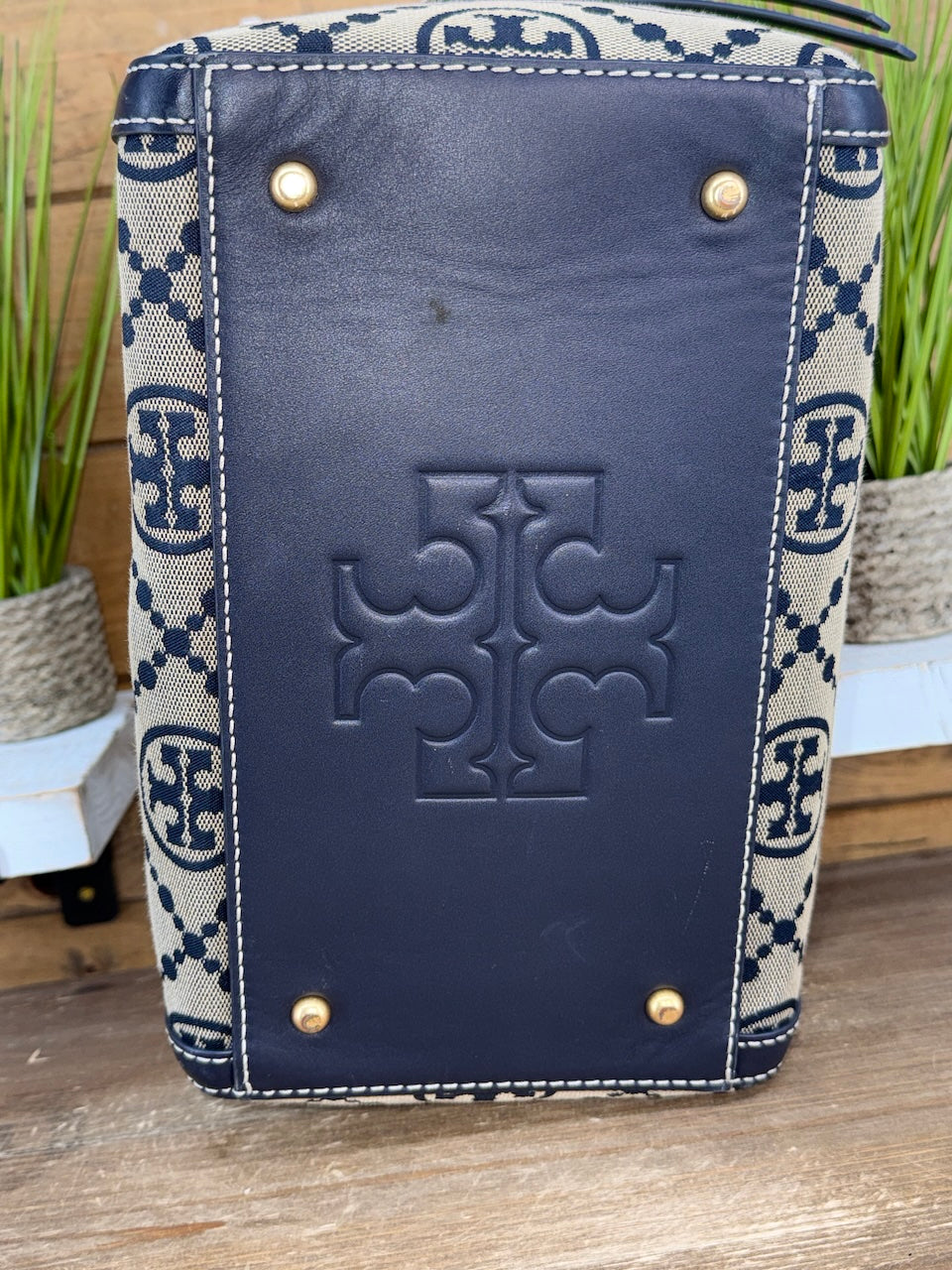 Navy blue leather case with a patterned flap on a wooden surface