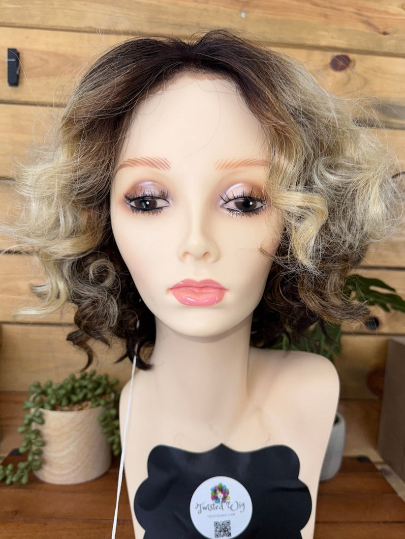 Mannequin head with a wig on a wooden background