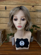 Mannequin head with a wig on a wooden surface
