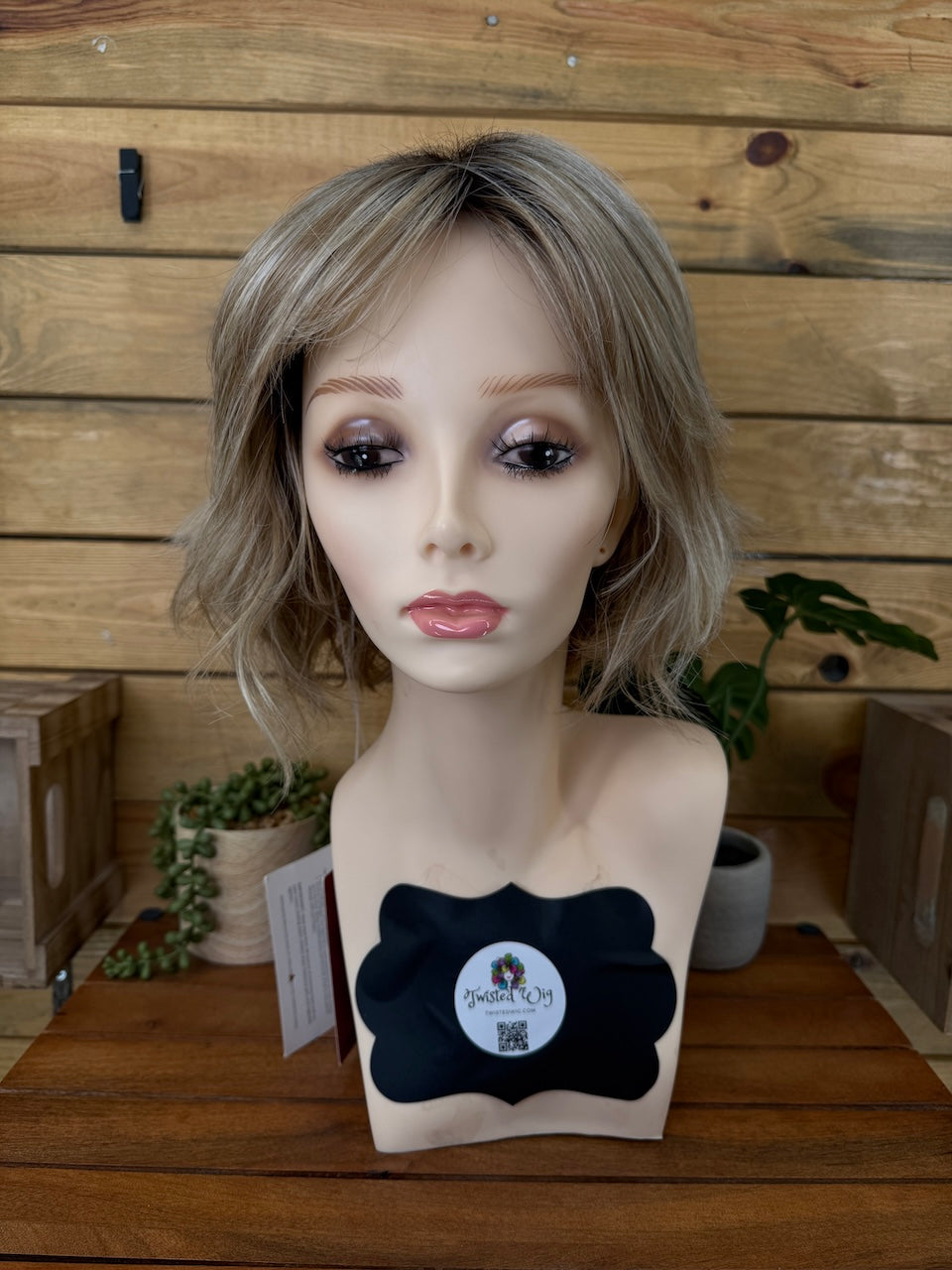 Mannequin head with a wig on a wooden surface