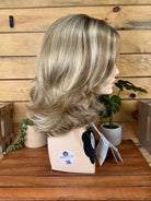 Blonde wig on a mannequin head with a wooden background