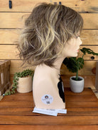 Wig on a mannequin head with a wooden background