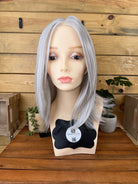 Silver wig on a mannequin head with a wooden background