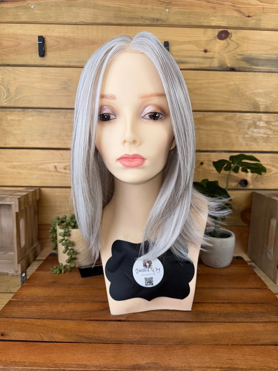 Silver wig on a mannequin head with a wooden background
