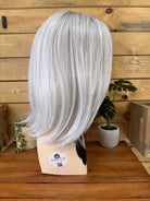 Silver wig on a mannequin head with a wooden background