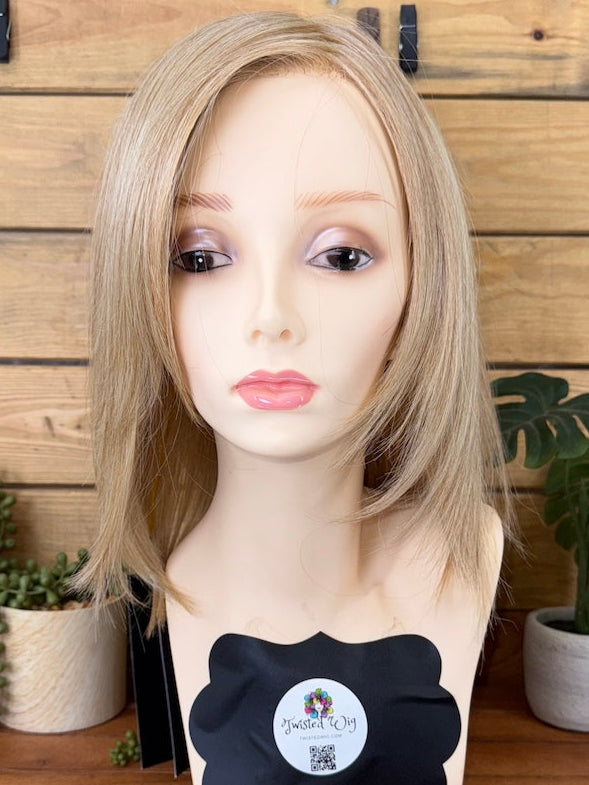 Blonde wig on a mannequin head with a wooden background