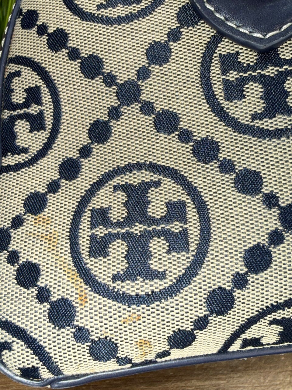 Close-up of a patterned fabric with a logo, likely from a brand.