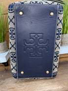 Navy blue leather case with a patterned flap on a wooden surface